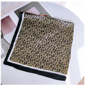 Detailed view of leopard print silk scarf with black and white striped border texture