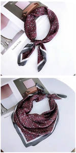 Detail of a red leopard print silk scarf with geometric grey and white striped borders