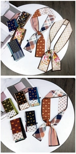 Detailed close-up of patterned silk scarves showing fine texture and diverse prints