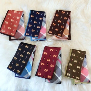 Close-up of assorted silk scarves featuring cute cat prints and classic plaid patterns