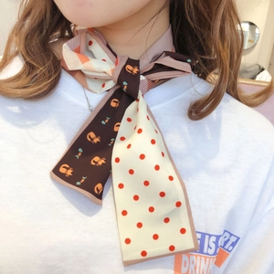 Detailed close-up of double-sided silk scarf with polka dots and cat pattern