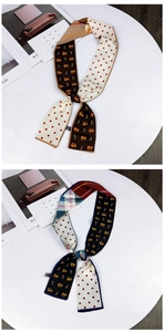 Detail of two-sided twilly scarves with fox and cat patterns on a fashion magazine