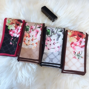 Detail view of retro floral silk scarves with geometric patterns on plush background