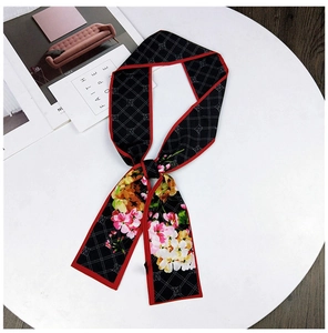 Detail of red-bordered twilly scarf with floral prints and black checkered pattern