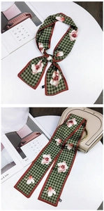 Floral magnolia print on green houndstooth scarf tied as a bow and on handbag handle