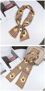 Floral and houndstooth silk scarf tied on a beige handbag with vintage style aesthetic