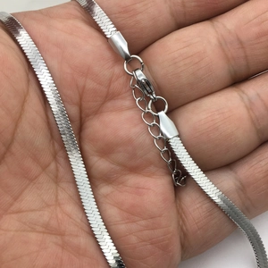 Silver stainless steel flat snake bone chain necklace held in hand with lobster clasp