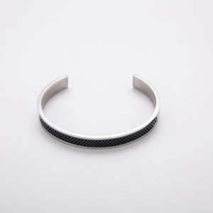 Minimalist stainless steel C-shaped cuff bracelet with black mesh inlay on white background