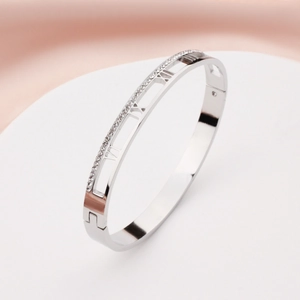 Polished stainless steel hollow bangle with Roman numerals and pavé diamonds inlay