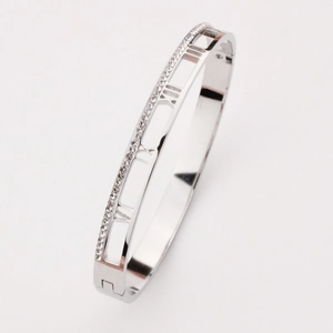 Macro detail of silver bangle featuring hollow Roman numerals and side pavé rhinestones