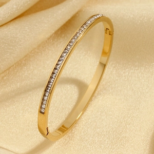 Elegant gold-plated bangle featuring square zircon channel setting on silk background