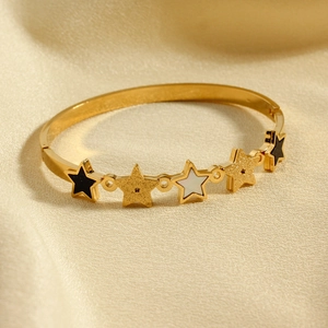 Polished gold stainless steel bangle featuring five pointed stars with black enamel inlay