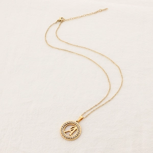 Gold stainless steel letter A necklace with crystal rhinestones on white fabric