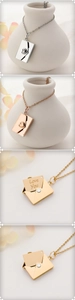 Détail des pendentifs enveloppe en trois couleurs montrant la gravure Love You