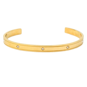 Macro view of gold stainless steel bangle with zircon stars and polished finish