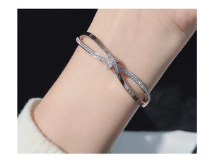 Detail of rose gold criss-cross bracelet with micro-pave crystals on model's wrist