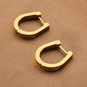 Polished U-shaped gold titanium steel hoop earrings shown on a textured background