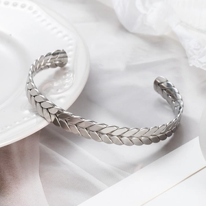 Minimalist silver stainless steel open bangle featuring a unique wheat pattern texture