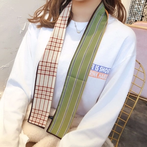 Detail of a double-sided long twilly scarf with plaid and stripe patterns on a model