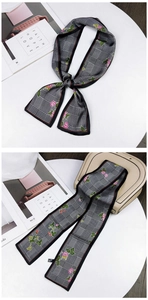 Detail of floral silk scarf tied as a bow on a beige leather handbag handle