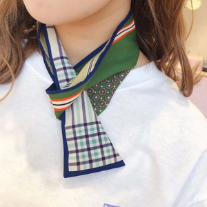 Detail view of plaid and geometric silk scarf with deep green, blue and orange patterns