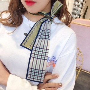 Close-up of vintage plaid silk scarf in olive green and beige worn as a neck tie