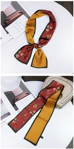 Close-up of double-sided twilly silk scarf with floral print and satin finish on a handbag