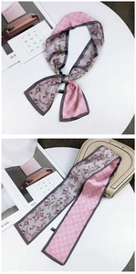 Detail of pink floral silk scarf with rose pattern and plaid design on white table