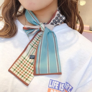 Detail of multi-use skinny silk scarf with blue and brown patterns on 100% polyester fabric