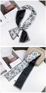 Close-up of double-sided floral twilly scarf with blue flower pattern and grey diamond print