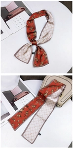 Floral and checkered double-sided silk skinny scarf styled as a bow on a beige handbag