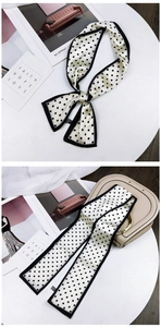 Close-up of black and white polka dot scarf tied as bow and handle wrap for a bag