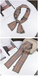 Detailed view of houndstooth silk twilly scarf tied on a handbag with chic accents