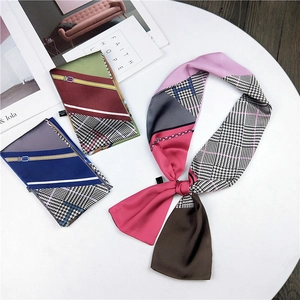 Detail of colorful silk scarf featuring houndstooth and geometric patterns on a table