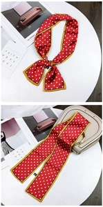 Close-up of red polka dot scarf with yellow border used as necktie and bag accessory
