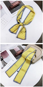 Close-up of yellow polka dot scarf used as a stylish handbag handle wrap and necktie