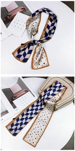 Detail of floral twilly silk scarf tied on a beige leather handbag with geometric patterns