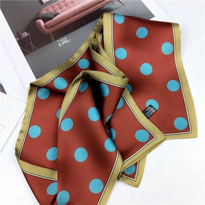 Vintage brick red polka dot scarf with blue dots and green border on white surface