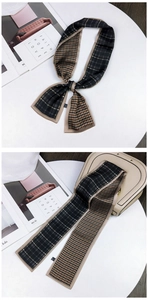 Detail of houndstooth skinny scarf wrapped on a handbag handle for elegant styling