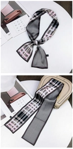 Detail of a floral houndstooth twilly silk scarf tied on a handle with soft lighting