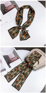 Detail of tiger print twilly scarf tied as a bow and wrapped on a beige handbag handle