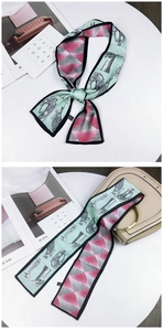 Detail of a dual-sided twilly scarf with animal print and geometric patterns on a handbag