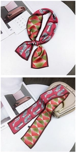 Close-up of wine red silk twilly with giraffe illustration and geometric patterns