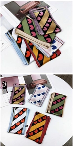Detailed view of various colorful silk scarves with heart patterns and diagonal stripes