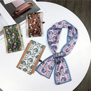 Flat lay of colorful animal print twilly scarves featuring bird and chain motifs