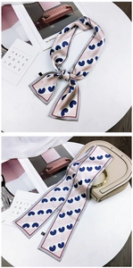 Pink and white striped twilly scarf with blue hearts tied on a handbag handle