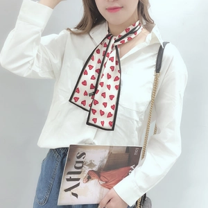 Foulard étroit en satin blanc à motifs de cœurs rouges porté comme bracelet élégant