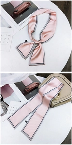 Close-up of pink striped silk scarf with contrast edges and elegant washing label detail