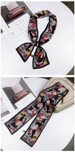 Close-up of animal-themed twilly scarf tied on a handbag with artistic camo print detail