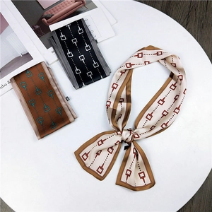 Close-up of three elegant silk twilly scarves with geometric belt buckle patterns